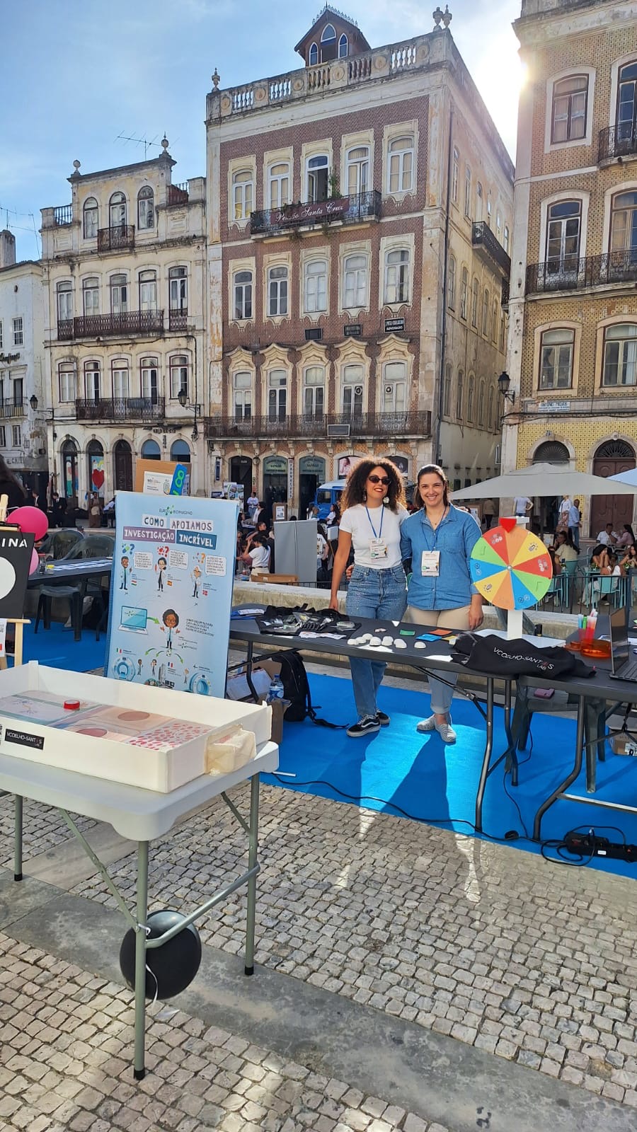Two women at a booth with games and posters.