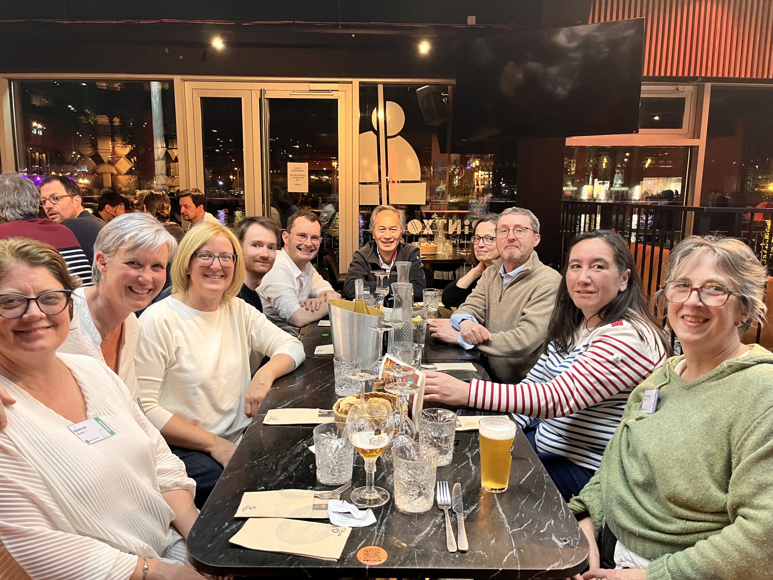 A group of smiling people sitting around the dinner table during the France BioImaging Annual Meeting 2026 in Rouen.