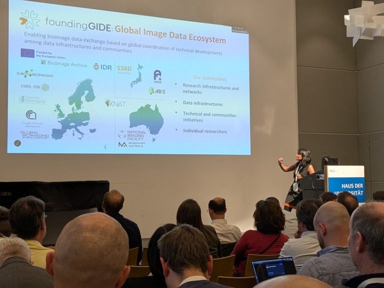Person presenting and audience listening in the 'Haus der Universität'