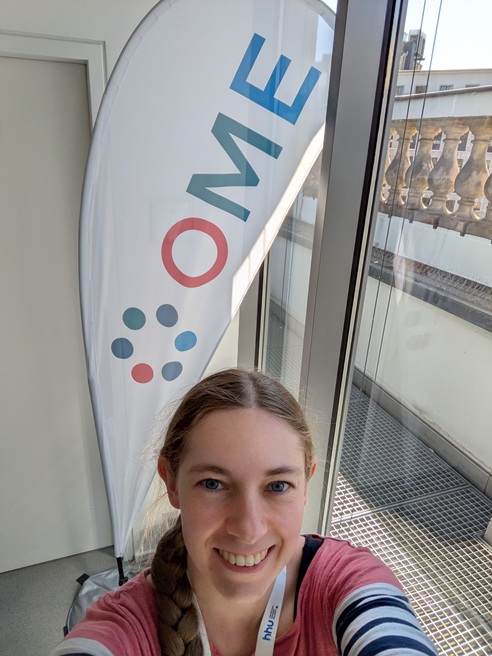 person standing in front of an OME banner