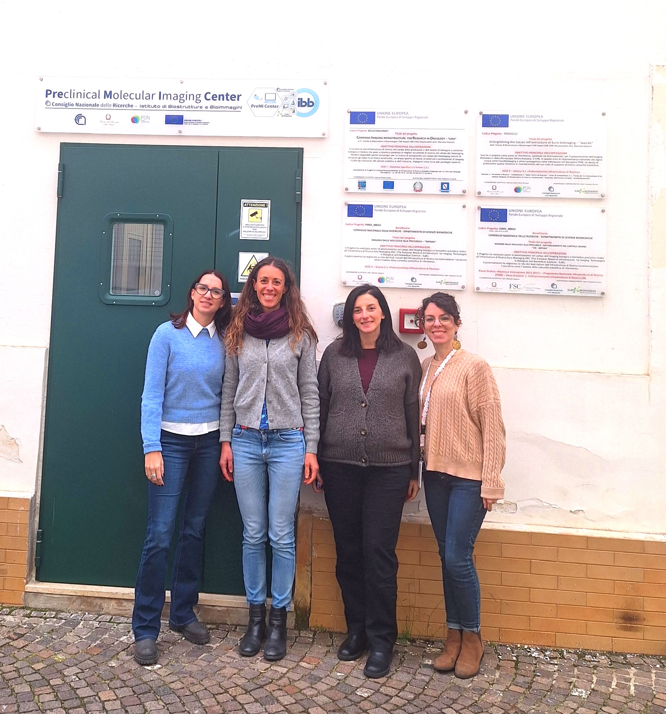 Picture of four women at the front door of the PreMI Center in the IBB-CNR institute in Napoli, Italy.