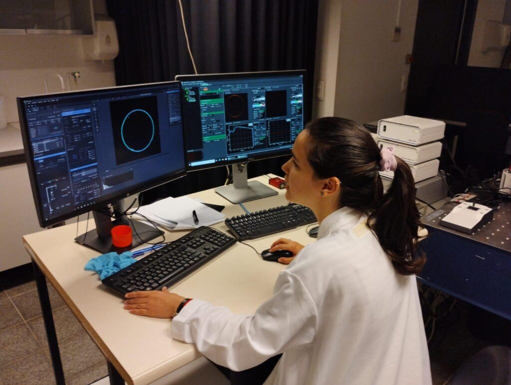 Jessica Aye Valdivia Pérez in front of the FLIM instrument. Photo by University of Hasselt.