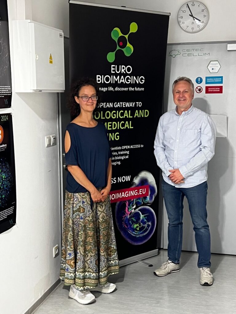Alessandra Viale and Milan Esner in front of a poster at the CEITEC Cellim Facility.